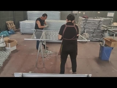 Οι εργάτες χρησιμοποιούν σύρμα για να συνδέσουν τον φράχτη και το σωλήνα του πλαισίου